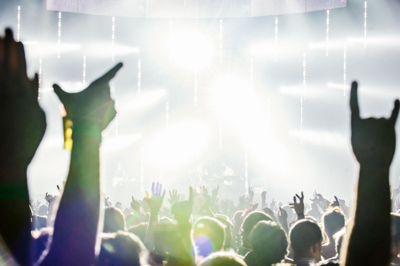 Crowd with hands raised at a live concert.