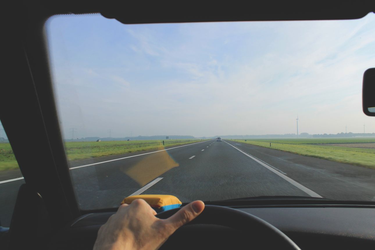 View from a car through the windshield, driving down an open highway.