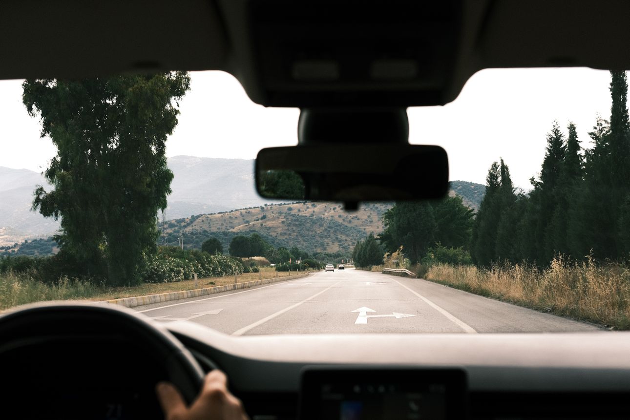 View from inside a car driving a scenic road, on the way somewhere.